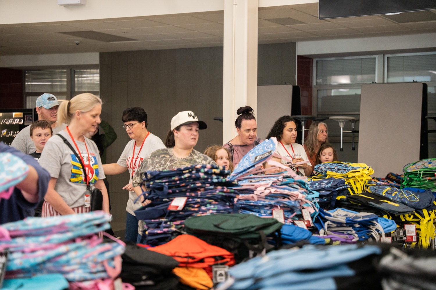 Families at tables of clothing and school supplies at the Back-to-School Give Back