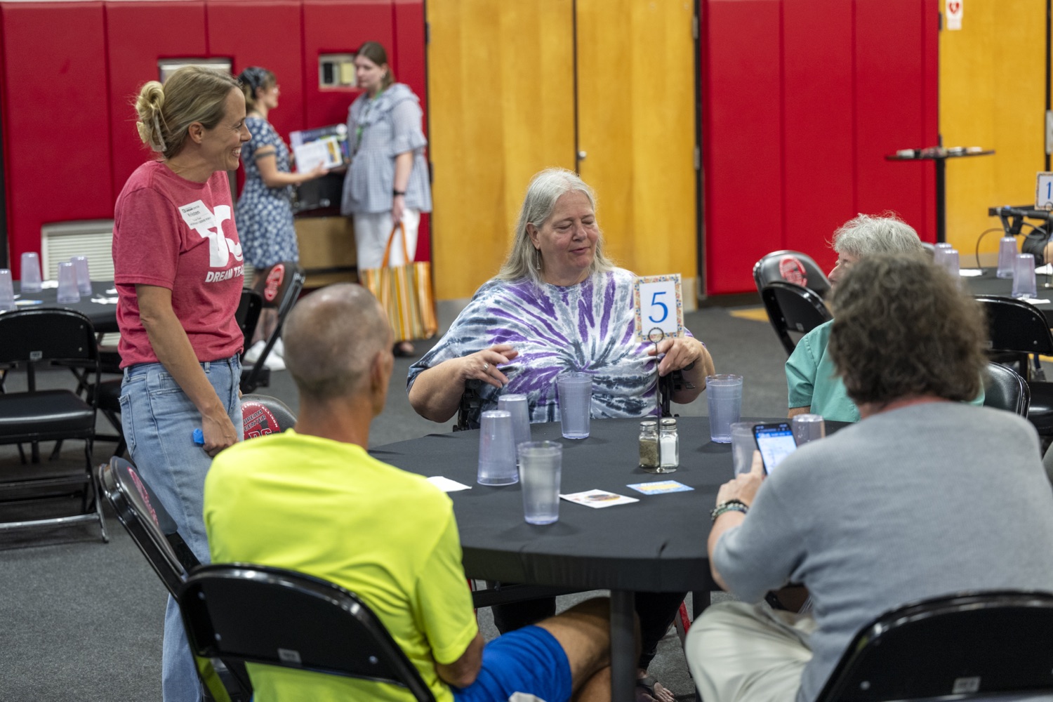 A Springfield Dream Center volunteer talking with guests around a table during a weekday program