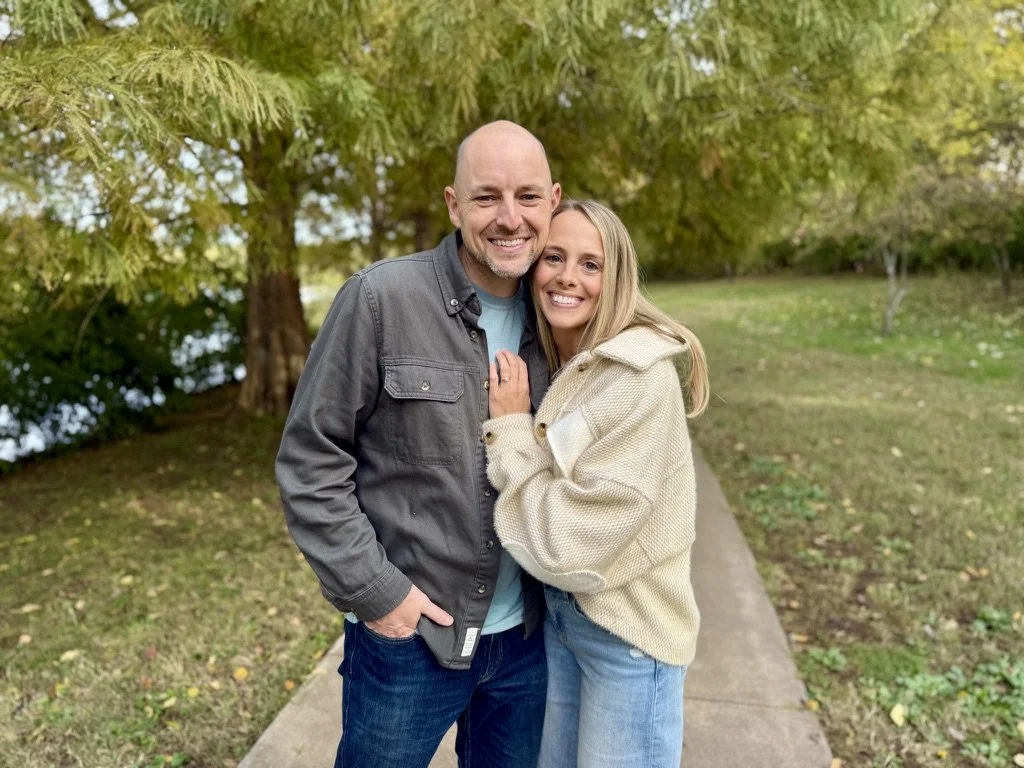 Drew and Kristen Williams outdoors on a path under the trees