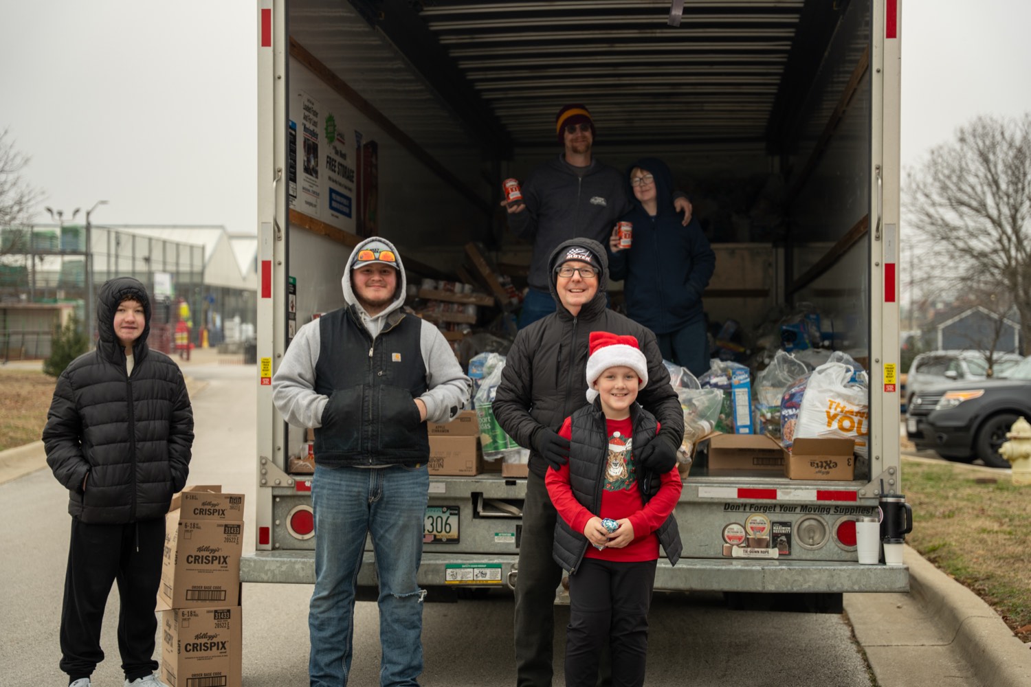 Volunteers standing at the back of a box truck loaded with donations