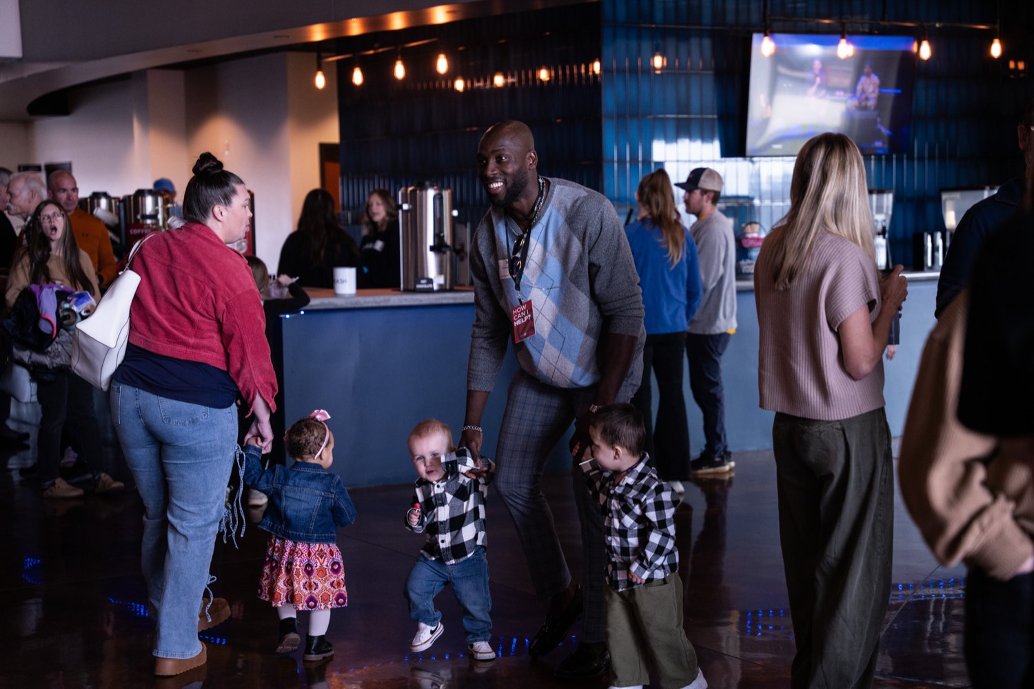 Families talking with a volunteer in the lobby before service